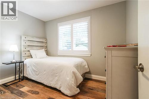 Wood-finish flooring, white window shutters, and a neutral wall color - 2105 Maplewood Drive, Burlington, ON - Indoor Photo Showing Bedroom