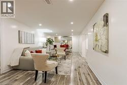 Recessed ceiling lighting, wood-finish flooring, white walls, and white trim - 