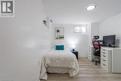 Recessed window, wood-finish flooring, built-in shelving, and a flush-mount ceiling light - 