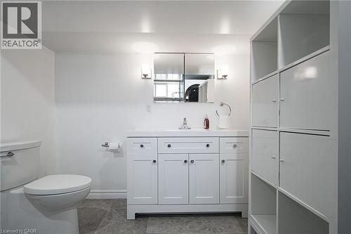 White shaker-style vanity with a single basin sink and wall-mounted sconces - 2105 Maplewood Drive, Burlington, ON - Indoor Photo Showing Bathroom
