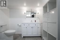 White shaker-style vanity with a single basin sink and wall-mounted sconces - 
