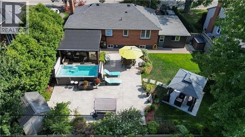 Expansive concrete patio featuring an in-ground swim spa with a retractable cover - 2105 Maplewood Drive, Burlington, ON - Outdoor