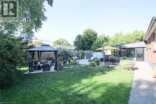 Expansive backyard featuring a lush lawn, a patio, and a sunroom extension - 2105 Maplewood Drive, Burlington, ON - Outdoor