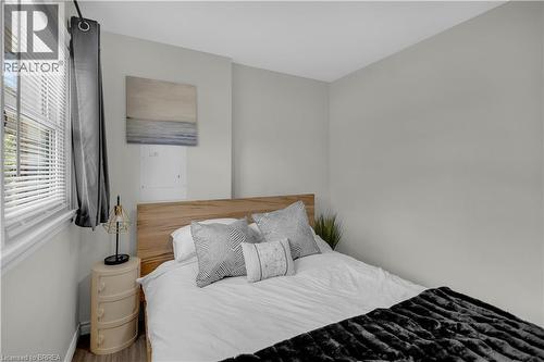 Bedroom featuring wood-finish flooring, light gray walls, a window with blinds, and a built-in electrical panel access - 450 Highland Road E, Kitchener, ON - Indoor Photo Showing Bedroom