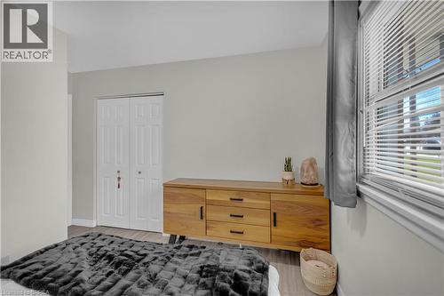 wood-finish flooring, and white bi-fold closet doors - 450 Highland Road E, Kitchener, ON - Indoor Photo Showing Bedroom