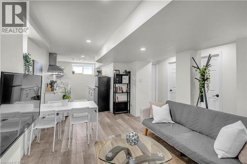 Open-concept living area featuring wood-finish flooring, recessed lighting, and a kitchen with a stainless steel range hood - 450 Highland Road E, Kitchener, ON - Indoor