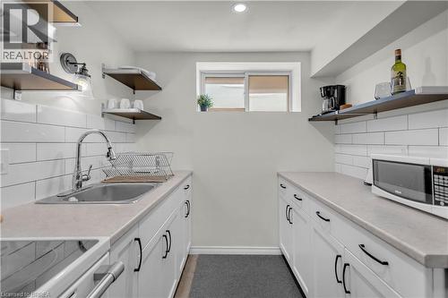 Lower Level Kitchen featuring white shaker-style cabinetry, a stainless steel sink with a high-arc faucet, and light-toned countertops - 450 Highland Road E, Kitchener, ON - Indoor Photo Showing Kitchen