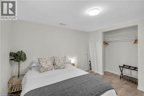 Well-lit bedroom Lower Level featuring light-toned walls, wood-finish flooring, a contemporary flush-mount ceiling light, - 450 Highland Road E, Kitchener, ON - Indoor Photo Showing Bedroom
