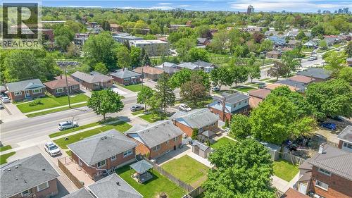 Aerial perspective showcasing a residential street with mature trees and a distant urban skyline - 450 Highland Road E, Kitchener, ON - Outdoor With View