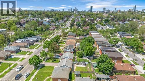 Residential neighborhood featuring mature trees, paved streets, sidewalks, and distant urban skyline - 450 Highland Road E, Kitchener, ON - Outdoor With View