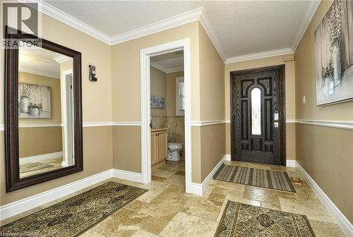 Travertine tile flooring, decorative front entry door with leaded glass, crown molding, chair rail molding, and a built-in wall sconce - 156 Copper Leaf Street, Kitchener, ON - Indoor Photo Showing Other Room