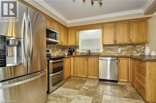 Warm wood cabinetry with stainless steel appliances, including a French-door refrigerator, double wall oven, and dishwasher - 156 Copper Leaf Street, Kitchener, ON - Indoor Photo Showing Kitchen With Stainless Steel Kitchen