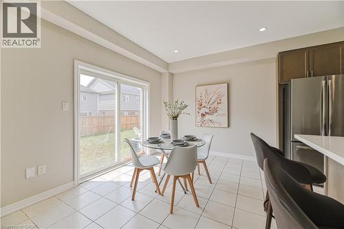 Recessed lighting, tile flooring, brown cabinetry, stainless steel refrigerator, and sliding glass door leading to a backyard - 24 Weatherall Avenue, Cambridge, ON - Indoor Photo Showing Dining Room