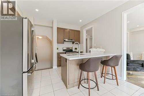 Kitchen featuring a central island with countertop, stainless steel appliances, wood-finish cabinetry, and tiled flooring - 24 Weatherall Avenue, Cambridge, ON - Indoor Photo Showing Kitchen