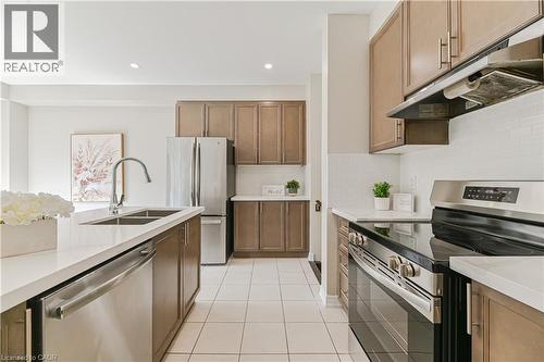 Kitchen featuring stainless steel appliances, light wood-finish cabinetry, white countertops, tile flooring, and a white subway tile backsplash - 24 Weatherall Avenue, Cambridge, ON - Indoor Photo Showing Kitchen With Double Sink With Upgraded Kitchen