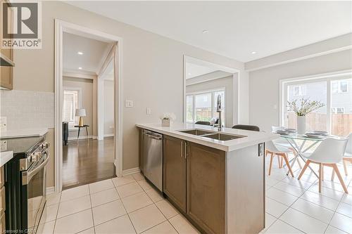 Kitchen featuring light-toned cabinetry, stainless steel appliances, white subway tile backsplash, white countertop, and tiled flooring - 24 Weatherall Avenue, Cambridge, ON - Indoor Photo Showing Kitchen With Double Sink With Upgraded Kitchen
