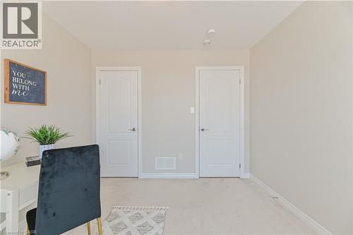 Light-colored walls with white trim, two paneled interior doors with brushed nickel hardware, and neutral carpeting - 24 Weatherall Avenue, Cambridge, ON - Indoor