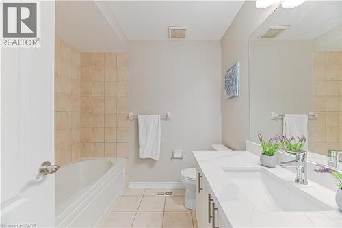Bathroom featuring a built-in tub, tiled shower surround, integrated sink, and a large wall-mounted mirror - 24 Weatherall Avenue, Cambridge, ON - Indoor Photo Showing Bathroom