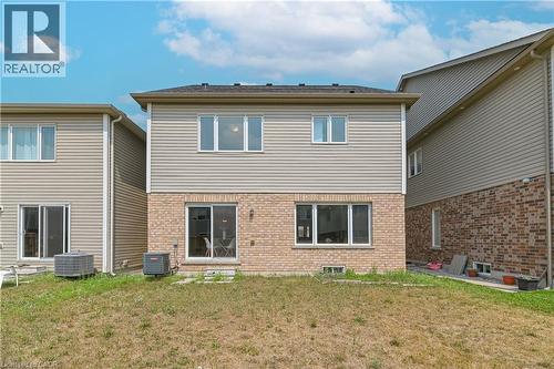 Rear exterior with a brick and siding facade, featuring upper-level windows and a ground-level sliding glass door - 24 Weatherall Avenue, Cambridge, ON - Outdoor With Exterior
