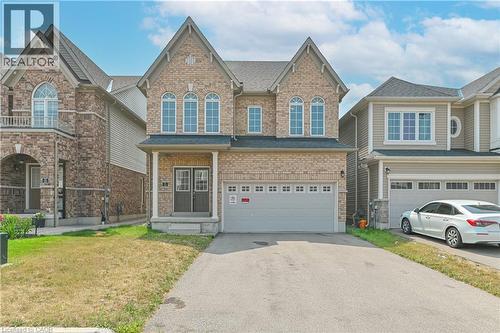 Brick facade with gabled rooflines, arched windows, covered porch, and an attached garage with a paved driveway - 24 Weatherall Avenue, Cambridge, ON - Outdoor With Facade