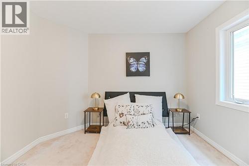 Recessed white window, light-colored carpeting, light-toned walls, and a dark headboard - 24 Weatherall Avenue, Cambridge, ON - Indoor Photo Showing Bedroom