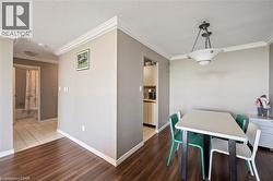 Wood-finish flooring, crown molding, and a built-in ceiling light fixture - 