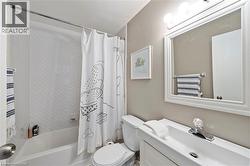 White vanity with an integrated sink, framed mirror, and a three-bulb light fixture - 