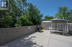 Concrete patio with a wood privacy fence and mature trees - 