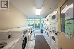 Shared laundry facility with multiple white front-loading and top-loading machines - 