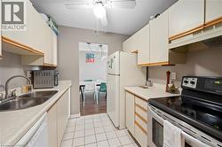 Galley kitchen featuring white cabinetry, light countertops, and a tile floor - 