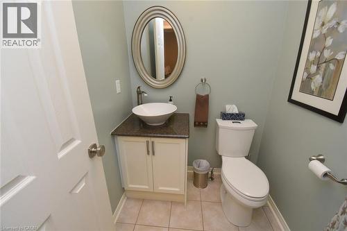 White shaker-style vanity with a vessel sink, dark countertop, and brushed nickel fixtures - 470 Amanda Crescent, Burlington, ON - Indoor Photo Showing Bathroom