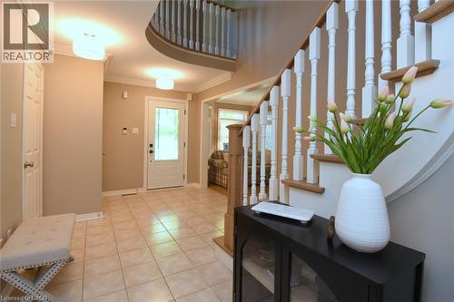 Welcoming foyer featuring a curved staircase with white balusters and wood handrail, ceramic tile flooring, recessed ceiling lighting - 470 Amanda Crescent, Burlington, ON - Indoor Photo Showing Other Room