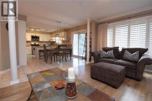 Hardwood-style flooring in the foreground, with tile flooring in the kitchen and dining area - 470 Amanda Crescent, Burlington, ON - Indoor Photo Showing Living Room