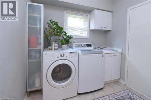 Utility room with a window, built-in cabinetry, and tile flooring - 470 Amanda Crescent, Burlington, ON - Indoor Photo Showing Laundry Room