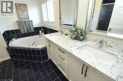 Dual undermount sinks set within a light-toned countertop, complete with chrome fixtures - 470 Amanda Crescent, Burlington, ON - Indoor Photo Showing Bathroom