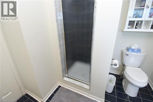 Frosted glass shower enclosure, white wall-mounted storage cabinet, and dark tiled flooring - 470 Amanda Crescent, Burlington, ON - Indoor Photo Showing Bathroom