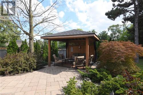 Paved patio with a wood-frame gazebo featuring a shingled roof and lattice side panels - 470 Amanda Crescent, Burlington, ON - Outdoor With Deck Patio Veranda