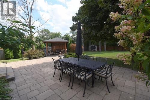 Expansive paver patio featuring a built-in wooden gazebo and a manicured lawn - 470 Amanda Crescent, Burlington, ON - Outdoor With Deck Patio Veranda