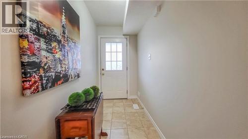 Entryway featuring a paneled door with glass inserts, neutral wall finishes, and tiled flooring - 128 Udvari Crescent Unit# A, Kitchener, ON - Indoor Photo Showing Other Room