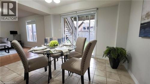Open-concept living area featuring a dining space with ceramic tile flooring and a patio door leading to an outdoor deck - 128 Udvari Crescent Unit# A, Kitchener, ON - Indoor Photo Showing Dining Room