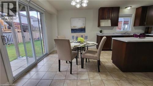 Spacious kitchen with wood-finish cabinetry, light-toned countertops, and a kitchen island - 128 Udvari Crescent Unit# A, Kitchener, ON - Indoor Photo Showing Dining Room
