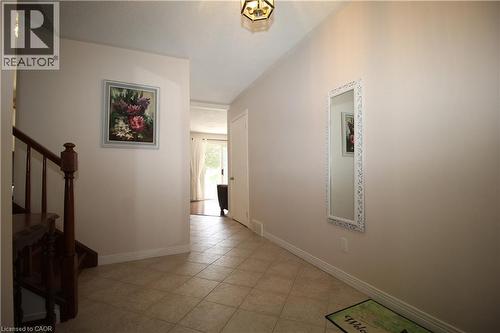 Entryway featuring neutral wall tones, tile flooring, a wooden staircase, and an overhead light fixture - 14 Berkley Crescent, Simcoe, ON - Indoor Photo Showing Other Room