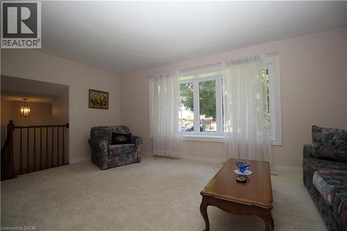Expansive living area with neutral carpeting and light-colored walls - 14 Berkley Crescent, Simcoe, ON - Indoor