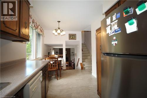 Kitchen featuring wood cabinetry, light-toned countertops, and a built-in dishwasher - 14 Berkley Crescent, Simcoe, ON - Indoor Photo Showing Kitchen