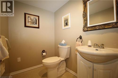 Pedestal sink with integrated vanity, ornate framed mirror, and warm neutral wall color - 14 Berkley Crescent, Simcoe, ON - Indoor Photo Showing Bathroom