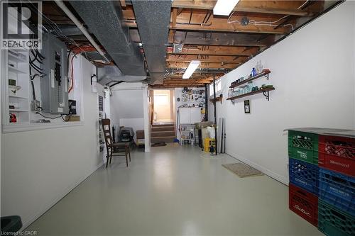 Unfinished basement featuring exposed wood beams, overhead fluorescent lighting, and a utility sink - 14 Berkley Crescent, Simcoe, ON - Indoor Photo Showing Basement
