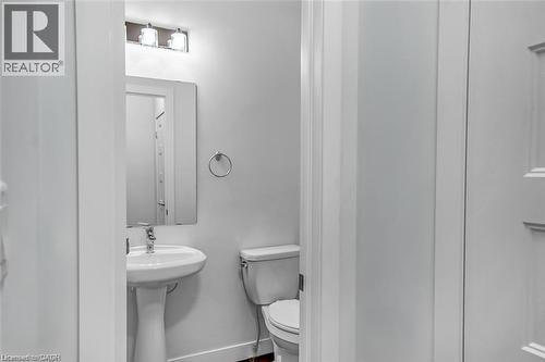 White pedestal sink with a chrome faucet, illuminated by a three-light vanity fixture, and a rectangular wall-mounted mirror - 961 Battery Park, London, ON - Indoor Photo Showing Bathroom