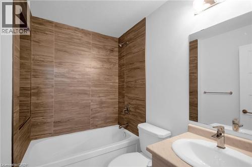 Bathtub with wood-finish tile surround and built-in shower niche - 961 Battery Park, London, ON - Indoor Photo Showing Bathroom