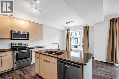 Kitchen featuring wood-finish flooring, light wood cabinetry, stainless steel appliances, and a central island with a double sink and integrated dishwasher - 961 Battery Park, London, ON - Indoor Photo Showing Kitchen With Double Sink