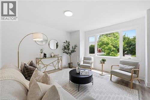 Spacious living area featuring large windows, light wood-finish flooring, and a modern ceiling fixture - 156 East 36Th Street, Hamilton, ON - Indoor Photo Showing Living Room